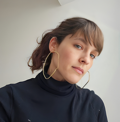 a woman wearing a black shirt and gold hoop earrings