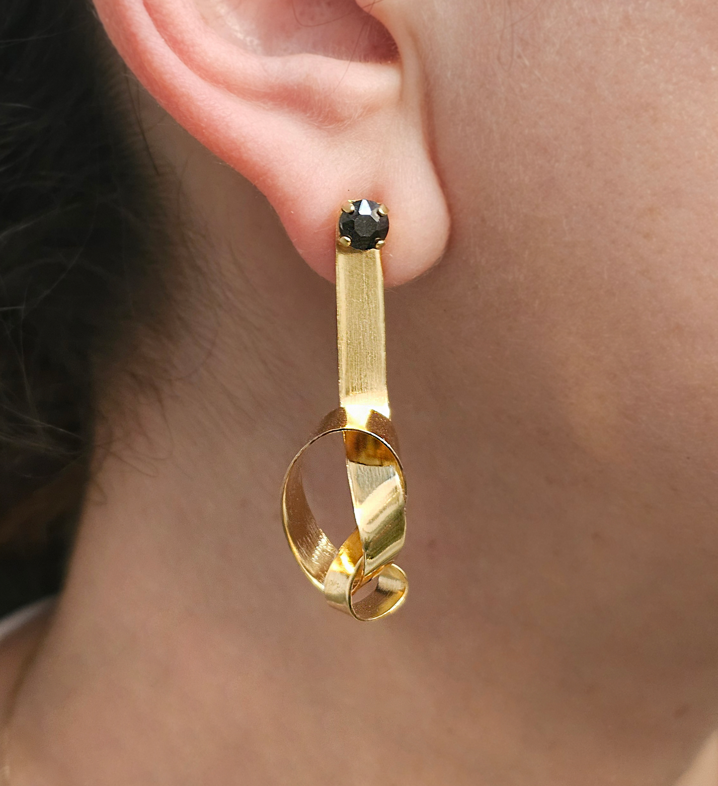 a close up of a person wearing a pair of earrings