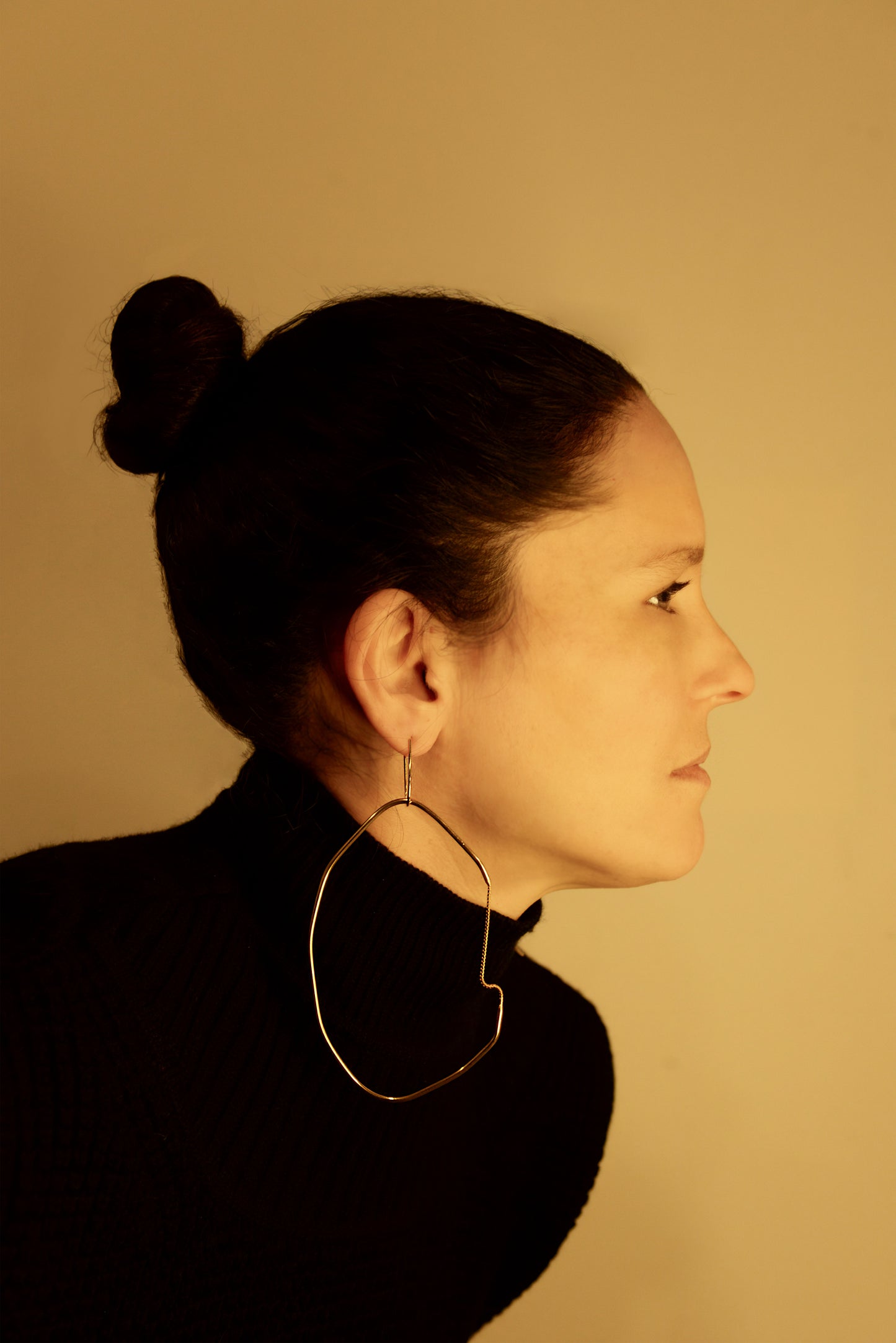 a woman wearing a black sweater and a pair of large hoop earrings