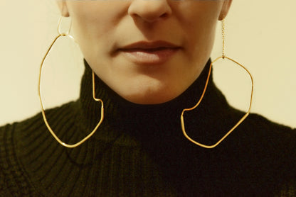 a close up of a person wearing large gold hoop earrings