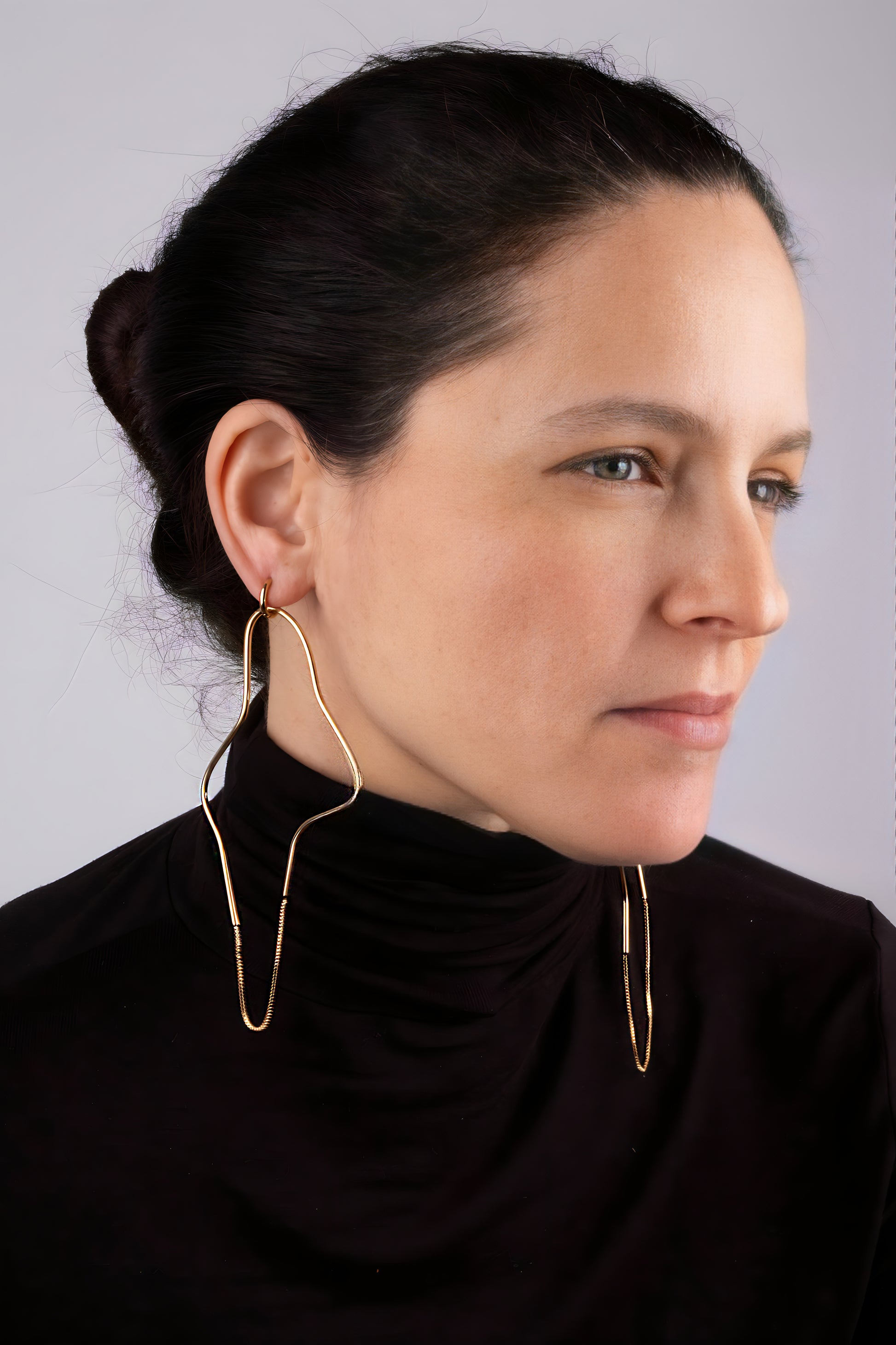 a woman wearing large gold hoop earrings