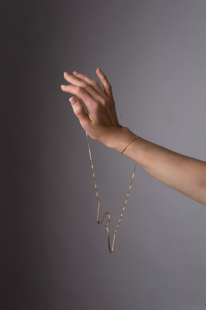 a woman's hand holding onto a necklace