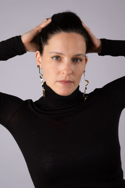 a woman in a black shirt is holding her hair
