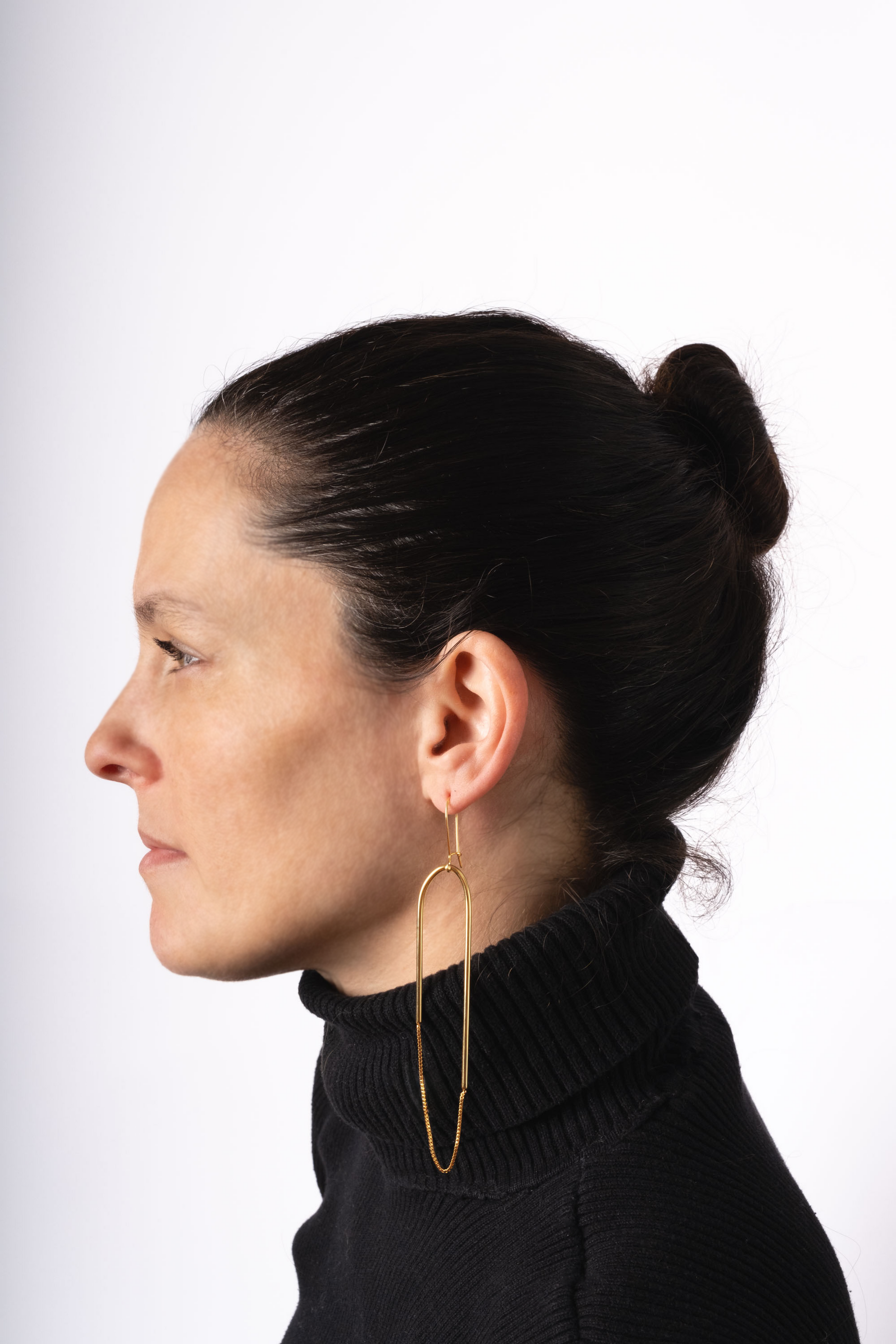 a woman wearing a black sweater and large gold hoop earrings