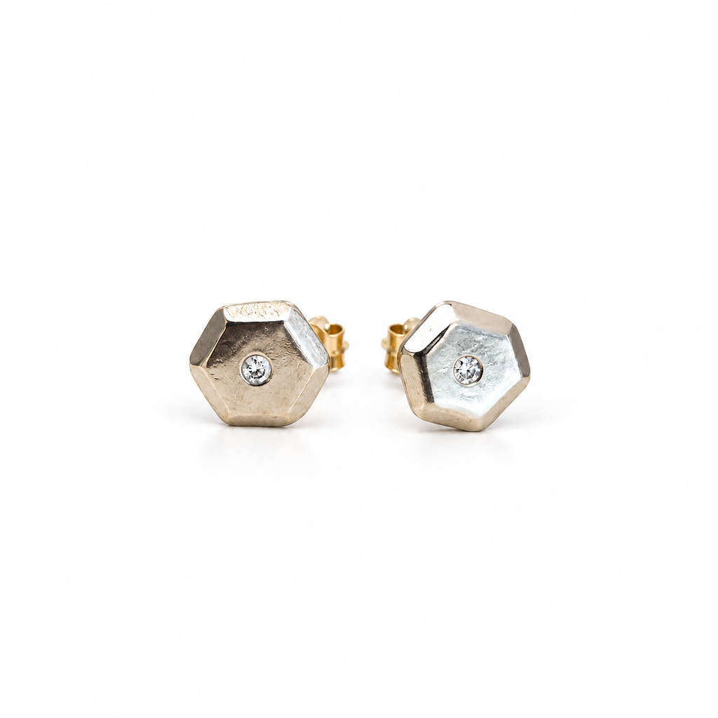 Front view of the Little Studs pair in 14k white gold, faceted hexagon studs with a small natural diamond in the centre of each