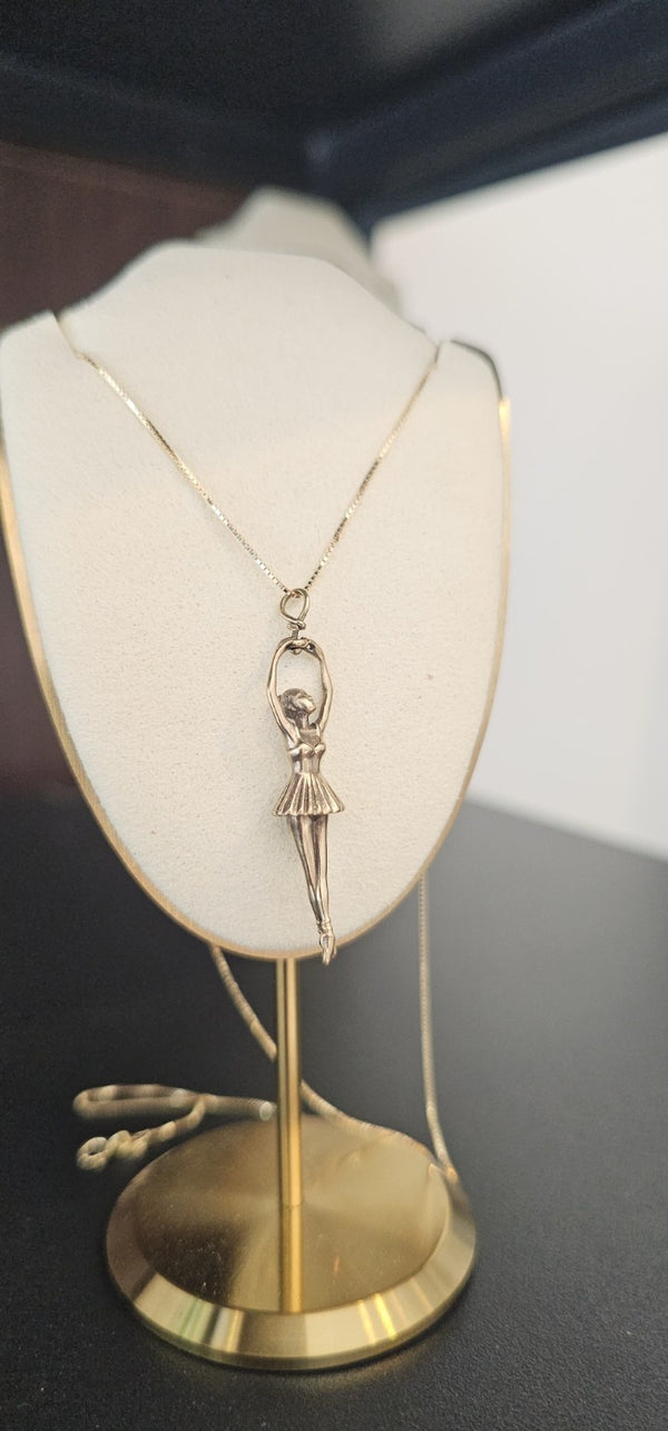 Ballerina Pendant in 14k gold on a box chain, on a display bust in the OTILYAS studio