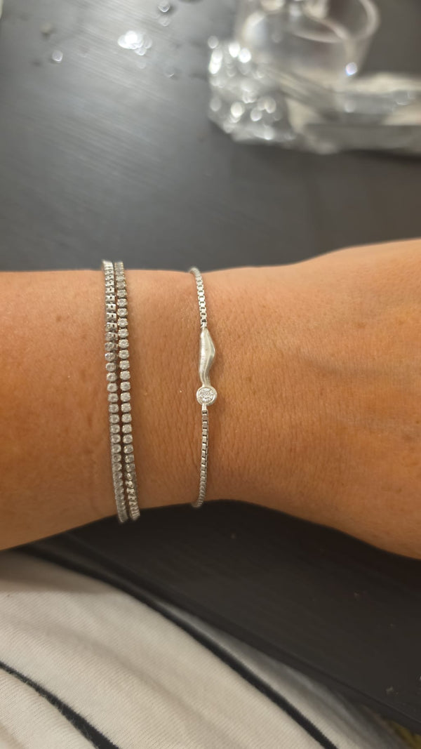 Cloud Bracelet, 18k white gold, worn on the wrist beside a tennis bracelet, in the OTILYAS studio