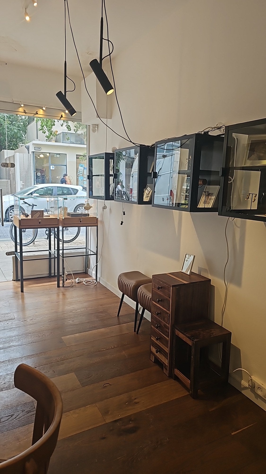 OTILYAS studio on Sheinkin 17, Tel Aviv: black wall display cases above a wooden floor