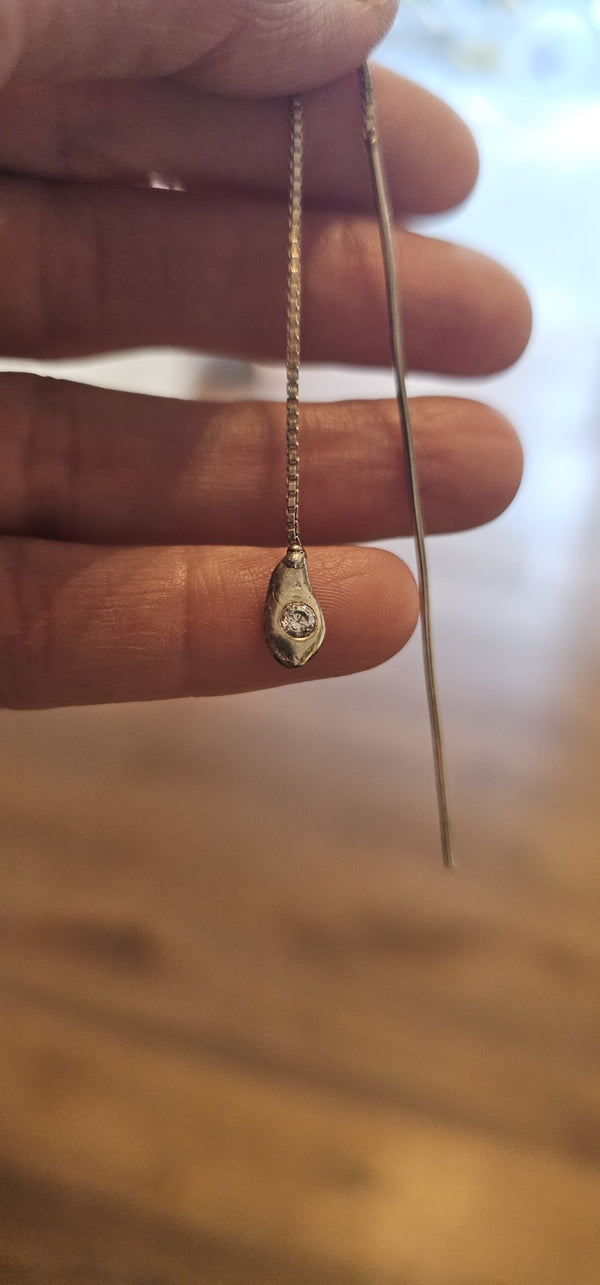 Irregular Threader in sterling silver with a lab-grown diamond, held in hand in the OTILYAS studio