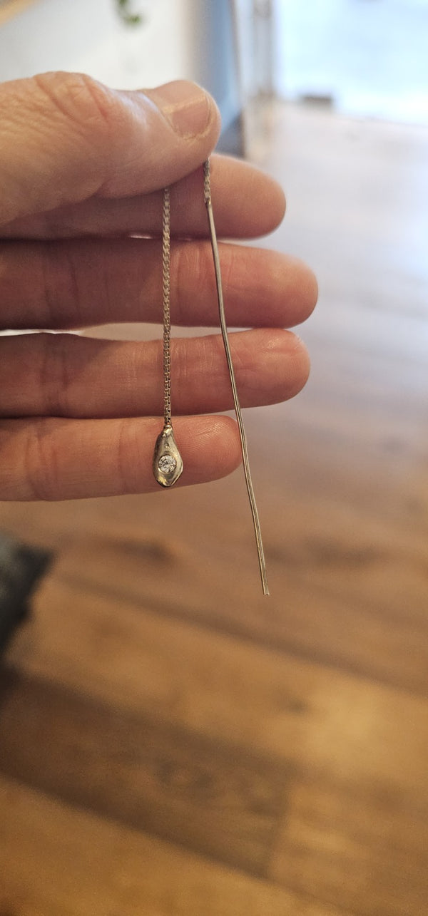 Irregular Threader in sterling silver with a lab-grown diamond, held in hand in the OTILYAS studio