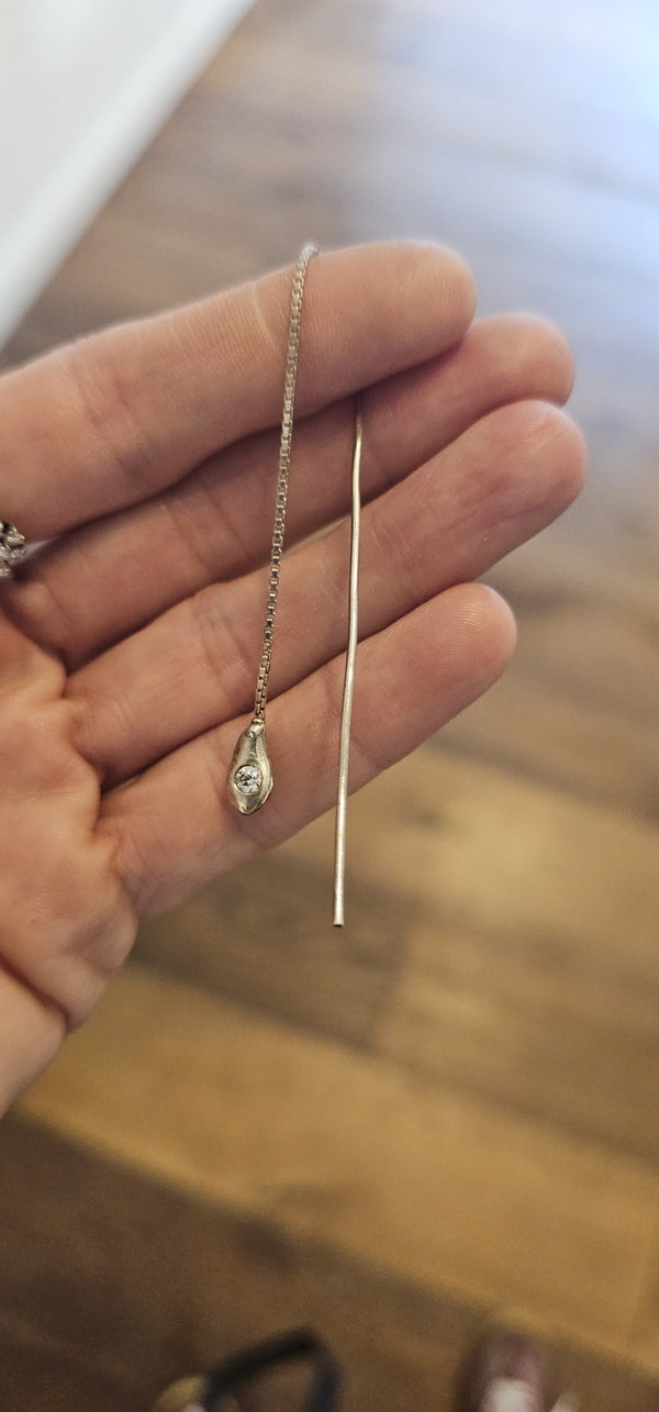 Irregular Threader in sterling silver with a lab-grown diamond, held in hand in the OTILYAS studio