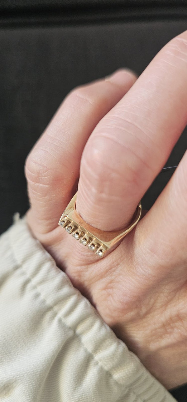 The Golden Line Ring worn on the hand, a row of six diamonds on a yellow gold bar