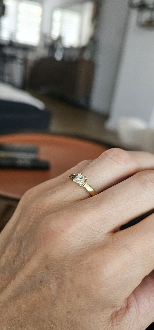 The Sun Square Ring worn on the hand, princess-cut diamond in a 4-prong setting