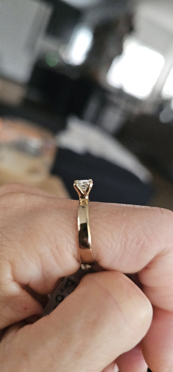 The Sun Square Ring held between fingers in the OTILYAS studio