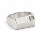 Side view of the silver pinky signet ring, showing the zircon set near one edge of the flat top